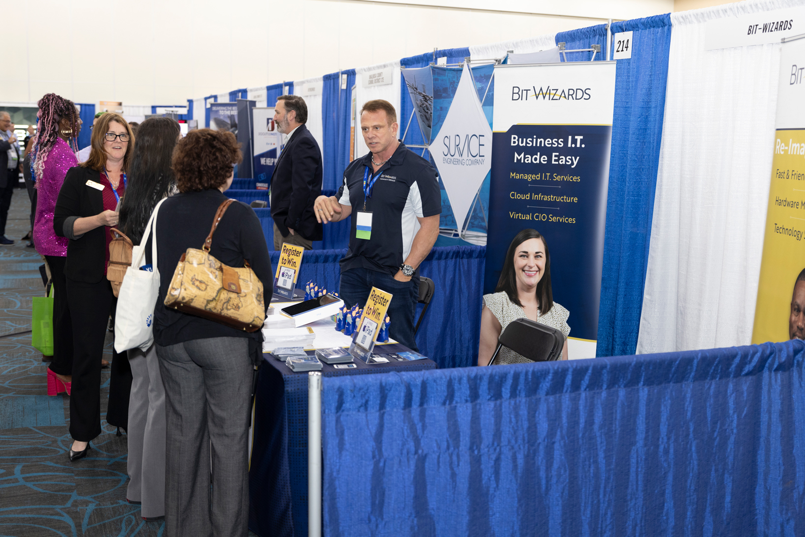 Conference booth with display and visitors for TeCMEN Industry Day